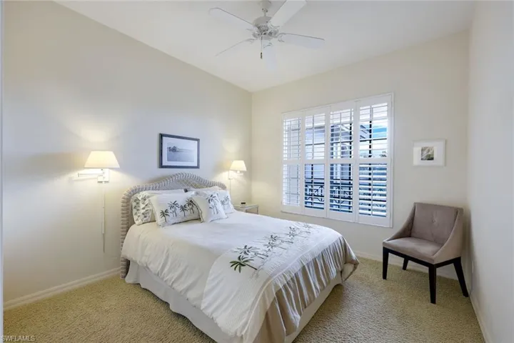 Guest Bedroom with light carpet and ceiling fan and Plantation Shutters and White wicker headboard and night stand
