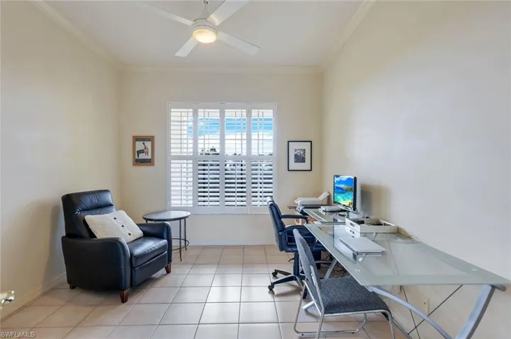 This Den/Office area could be third bedroom all you would need to do is add a bifold door to Hallway closet. This 11' x 14'  room has plenty of room to be both a spill-over bedroom with crown molding, light tile floors, ceiling fan, and Plantation Shutters.