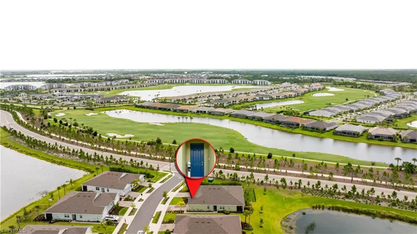 Aerial perspective of suburban area featuring a large body of water and a golf course