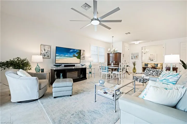 Living room with a chandelier, a ceiling fan, and light tile patterned flooring