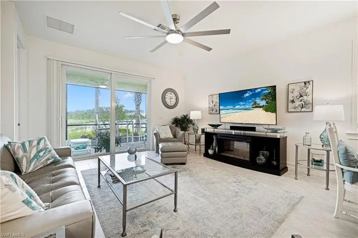 Living area featuring ceiling fan and tile patterned flooring