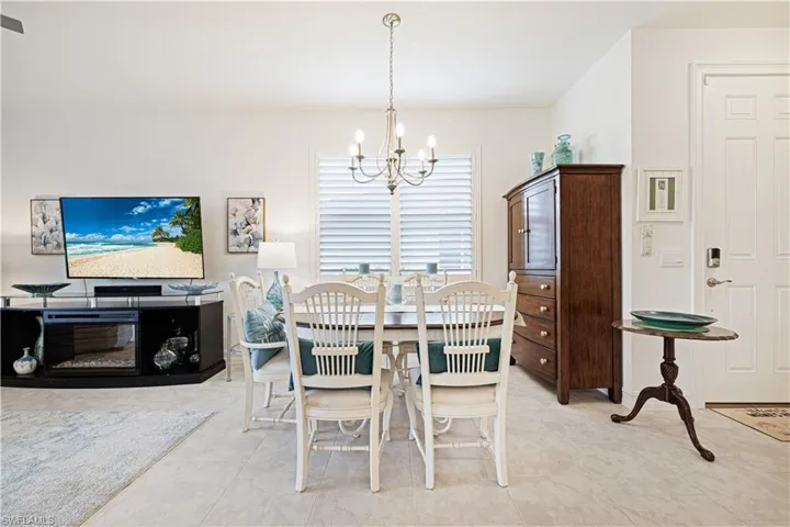 Dining room with a chandelier and light tile patterned flooring