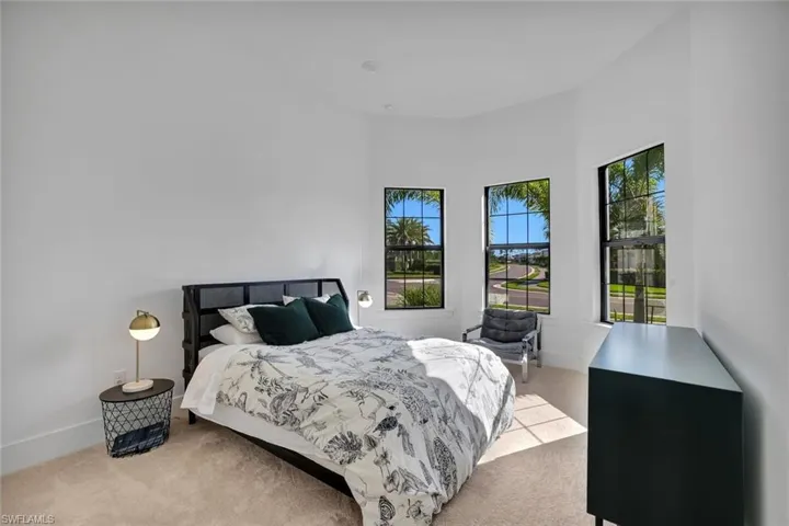 Bedroom with light carpet and a high ceiling