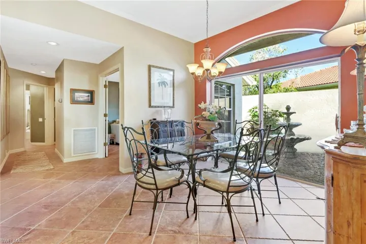 Dining area featuring light tile patterned flooring and a notable chandelier