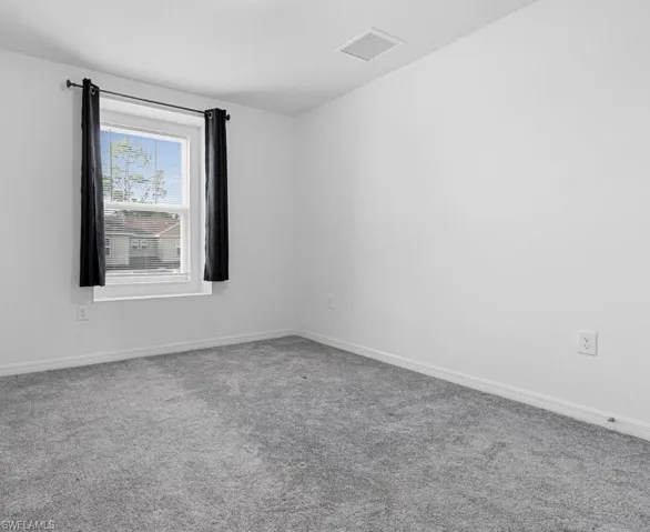 Carpeted empty room with baseboards