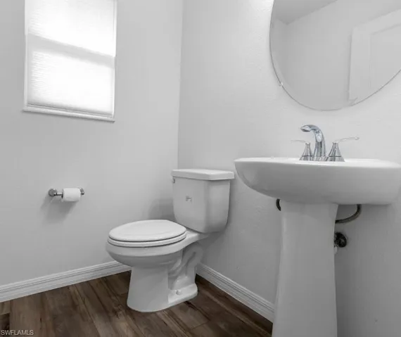 Bathroom featuring dark wood finished floors and baseboards
