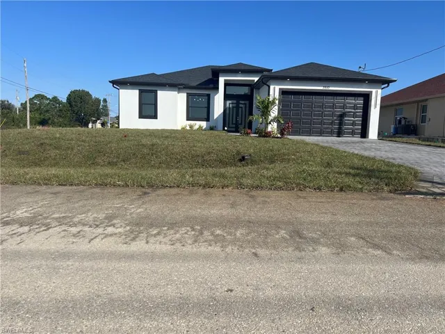 View of front of house featuring a garage and a front yard