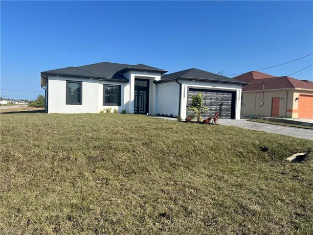 View of front of home with a garage and a front yard