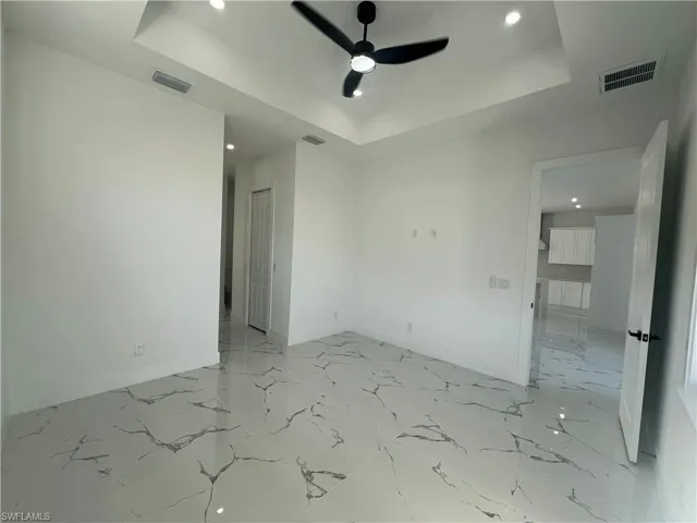 Empty room with a tray ceiling and ceiling fan
