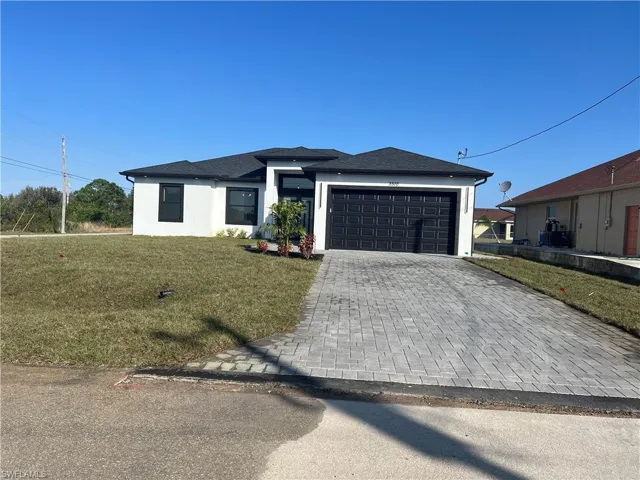 View of front of house with a front yard and a garage