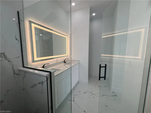 Bathroom with vanity and a shower with shower door