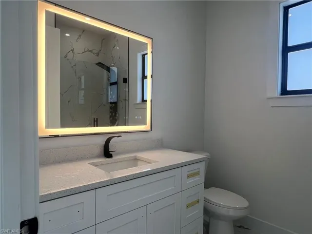 Bathroom with a shower, vanity, and toilet
