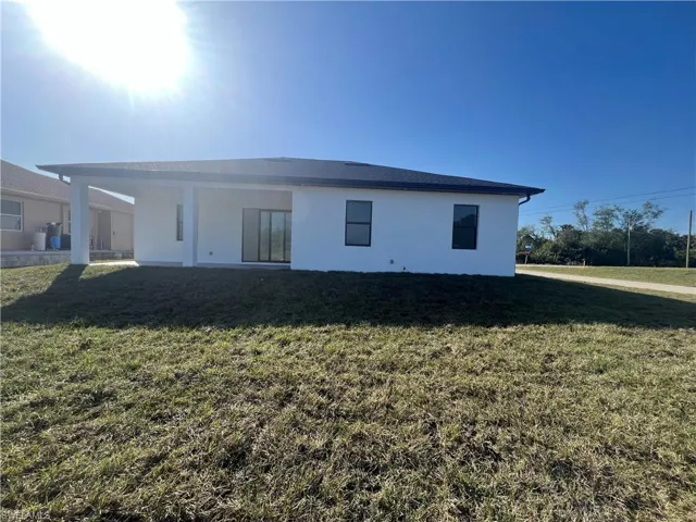 Back of house with a yard