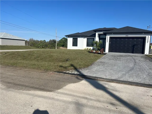 View of front of house featuring a garage and a front yard