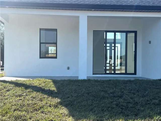 View of exterior entry featuring a lawn