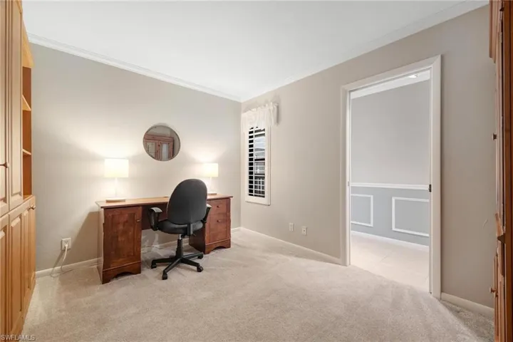 Carpeted office space with crown molding