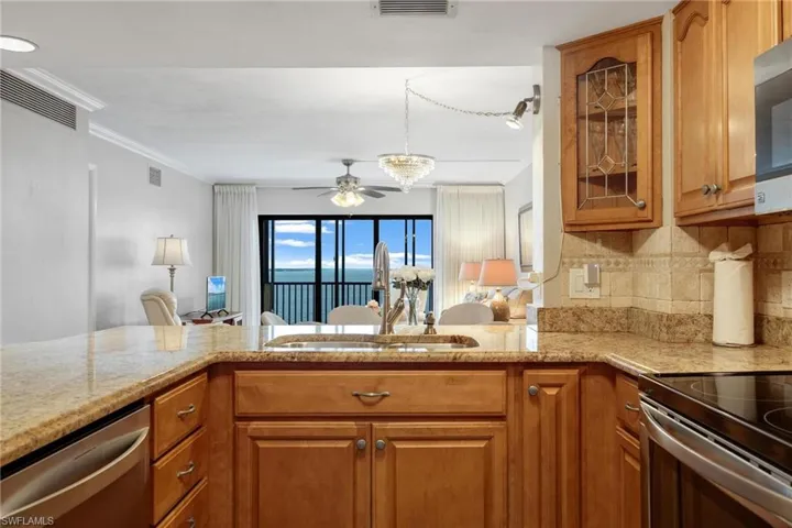 Kitchen with ornamental molding, stainless steel dishwasher, sink, tasteful backsplash, and ceiling fan