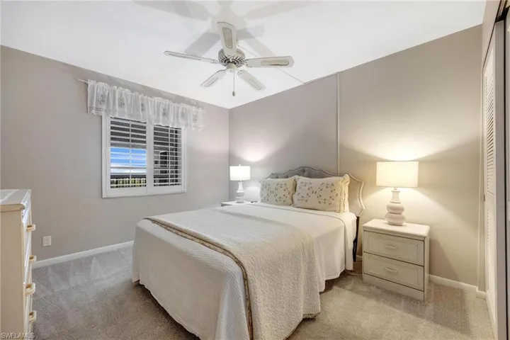Carpeted bedroom with a closet and ceiling fan