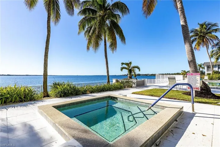 View of pool with a community hot tub and a water view