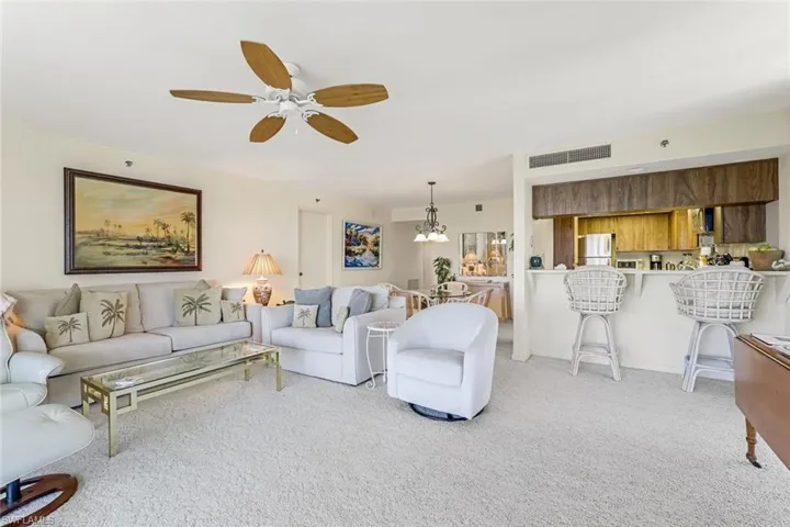 Living area with light carpet and ceiling fan