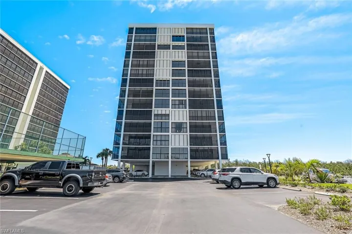 View of apartment building / complex featuring uncovered parking
