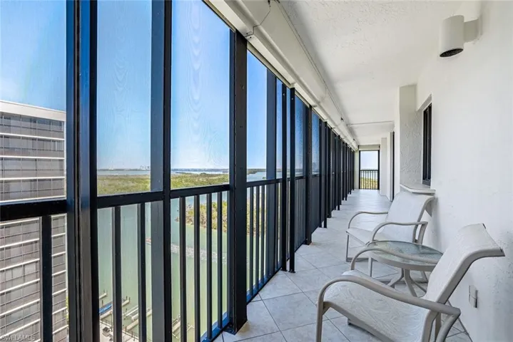 Balcony featuring a sunroom and a water view