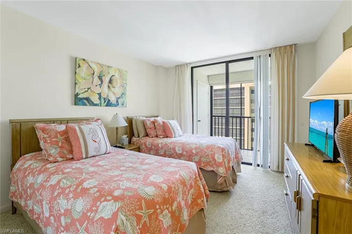 Bedroom with expansive windows, light colored carpet, and access to exterior
