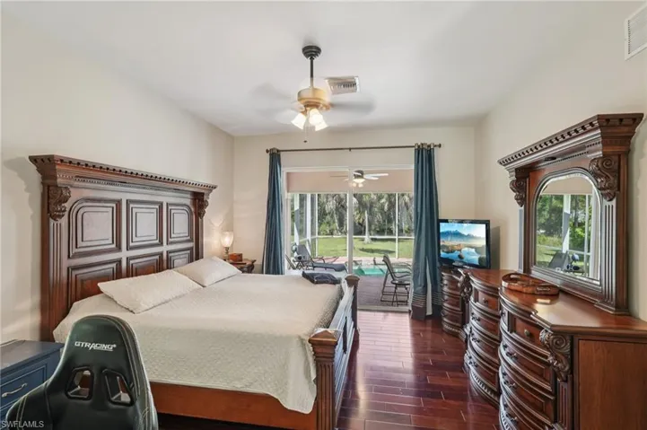 Bedroom with dark wood-style floors, access to outside, and ceiling fan