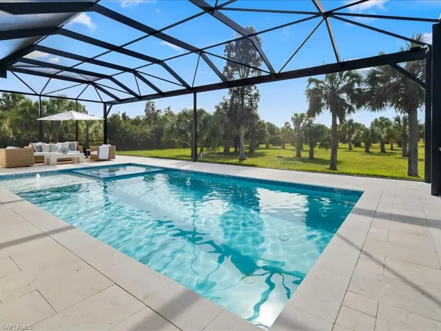 Swimming pool featuring a yard, a lanai, a sunroom, and outdoor lounge area