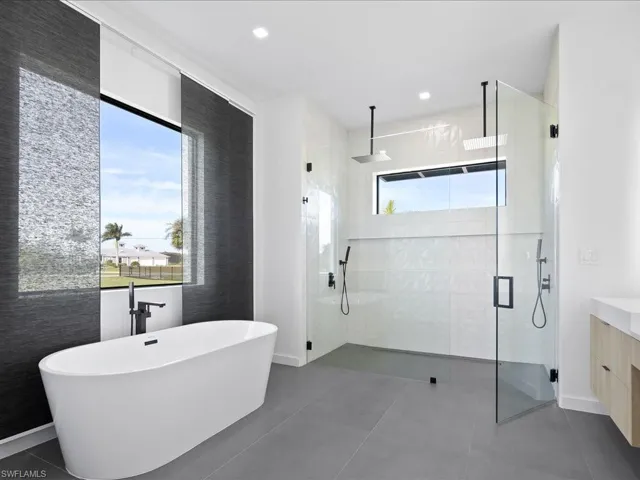 Bathroom with vanity, a freestanding tub, and a stall shower