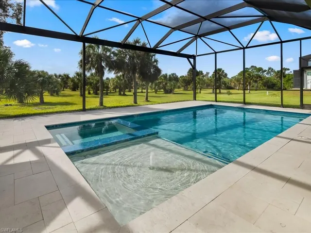 View of swimming pool with a lawn, a lanai, a sunroom, a pool with connected hot tub, and a patio