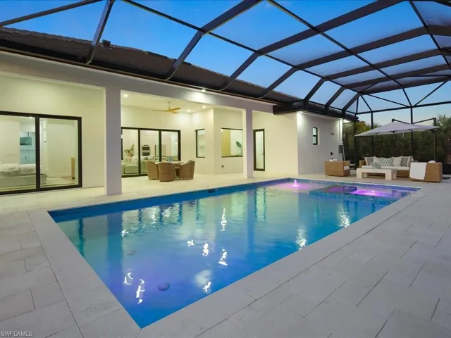 Outdoor pool with outdoor lounge area, glass enclosure, a patio area, and a sunroom