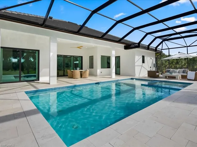 Outdoor pool featuring a sunroom, an outdoor hangout area, a lanai, and a patio