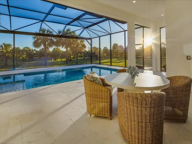 Swimming pool featuring a sunroom, glass enclosure, outdoor dining area, and a patio