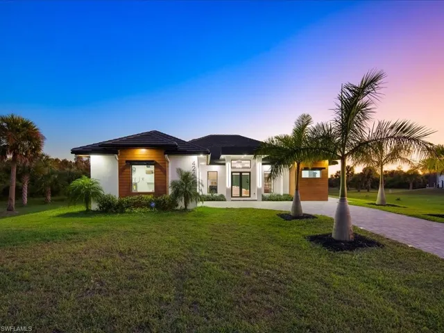 Prairie-style house featuring decorative driveway, a front yard, and stucco siding