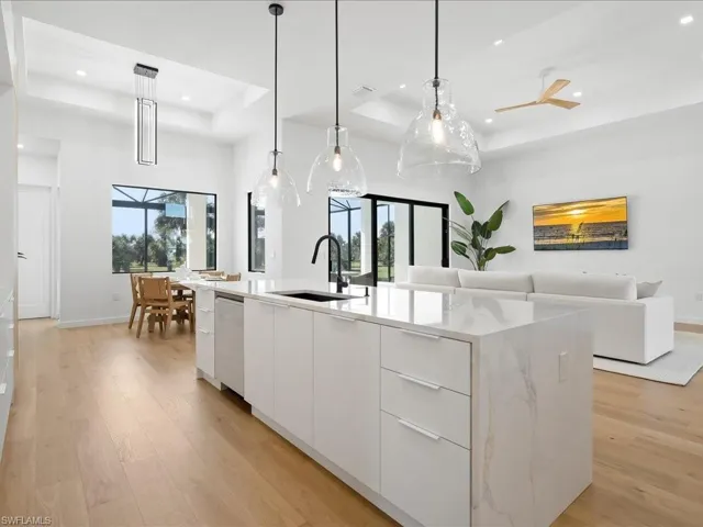 Kitchen with modern cabinets, white cabinetry, pendant lighting, light wood-type flooring, and recessed lighting