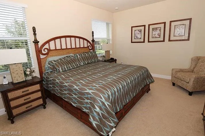 Bedroom with light carpet and multiple windows
