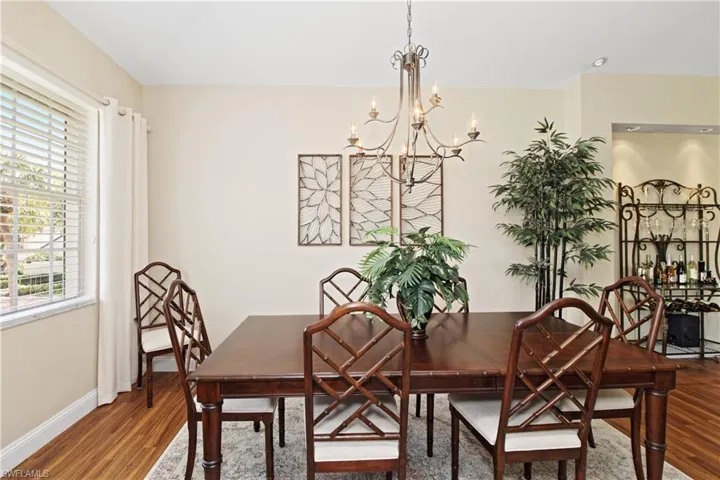 Dining space with wood finished floors and a chandelier