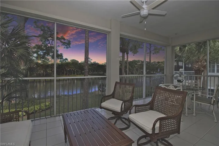Sunroom / solarium with a water view and tile patterned flooring