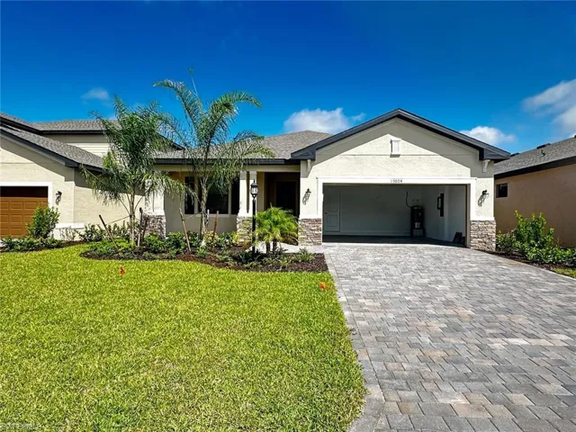 Single story home featuring stone siding, stucco siding, and decorative driveway