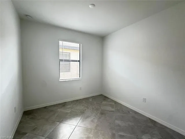 Unfurnished room featuring baseboards and light tile patterned flooring