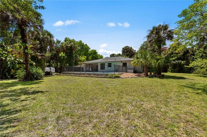 Expansive green lawn surrounds a single-story residence featuring a screened patio area