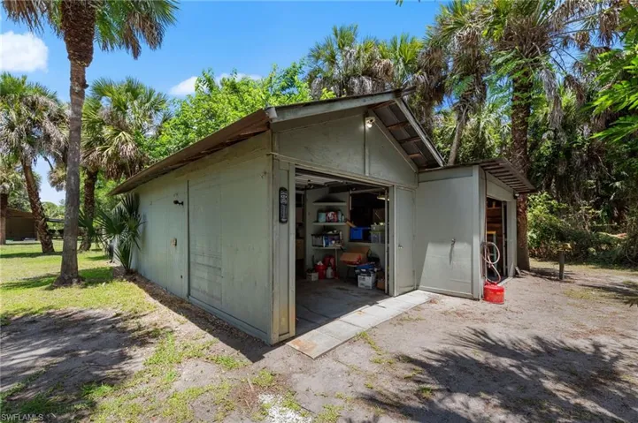 Detached storage building featuring a roll-up door, side entry, and an extended lean-to shed