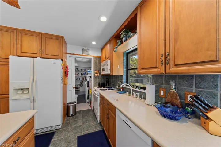 Kitchen featuring wood cabinetry, light countertops, and a tiled backsplash