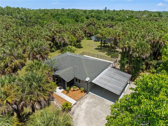 Property featuring a dark green shingle roof and an attached metal carport