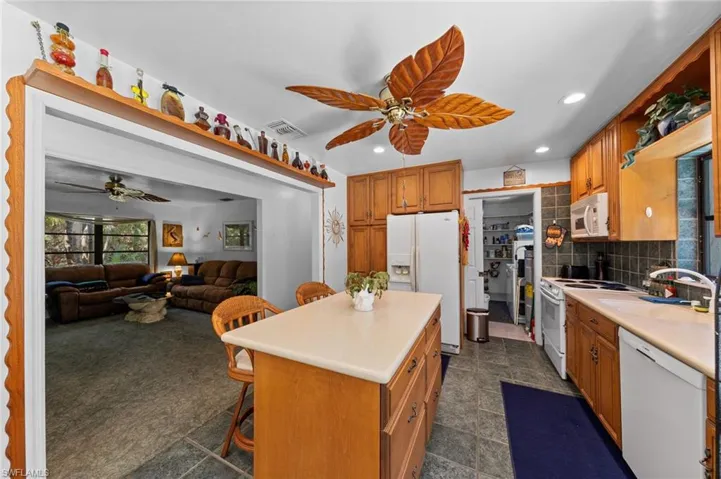 Kitchen featuring wood cabinetry, a center island with a light-toned countertop, and recessed lighting