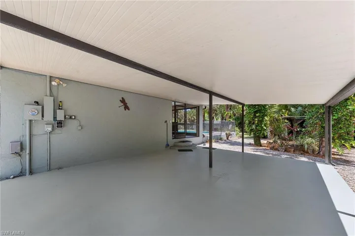 Expansive covered patio featuring a light-toned ceiling, a smooth concrete floor, and direct access to a screened outdoor space