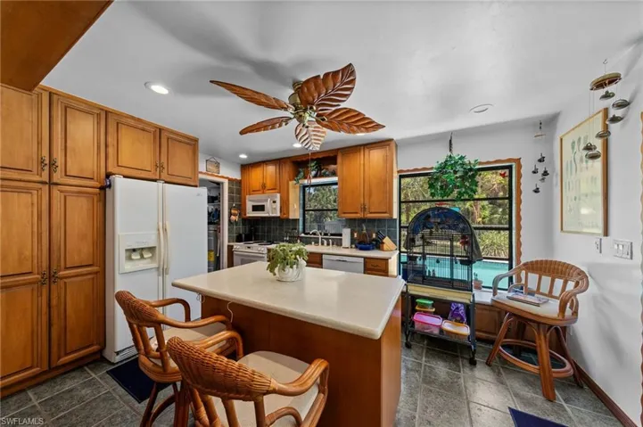 Kitchen featuring wood cabinetry, an island with countertop, and tile flooring