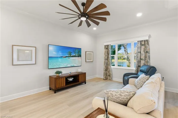 Living area with light wood-style flooring, crown molding, ceiling fan, and recessed lighting