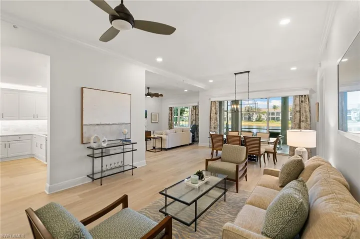 Living room with crown molding, light wood-type flooring, ceiling fan, and recessed lighting